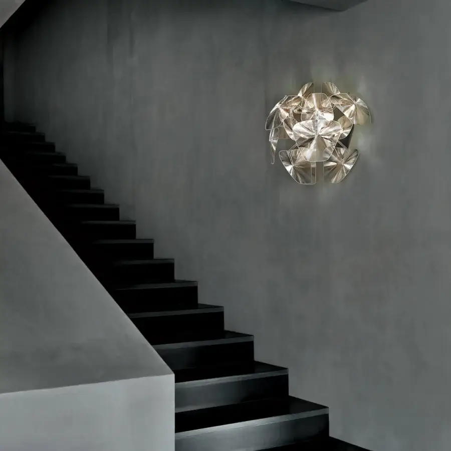 Distinguished Luceplan Hope Wall Lamp with a polished stainless-steel frame and transparent polycarbonate petal-like lenses creating brilliant reflections