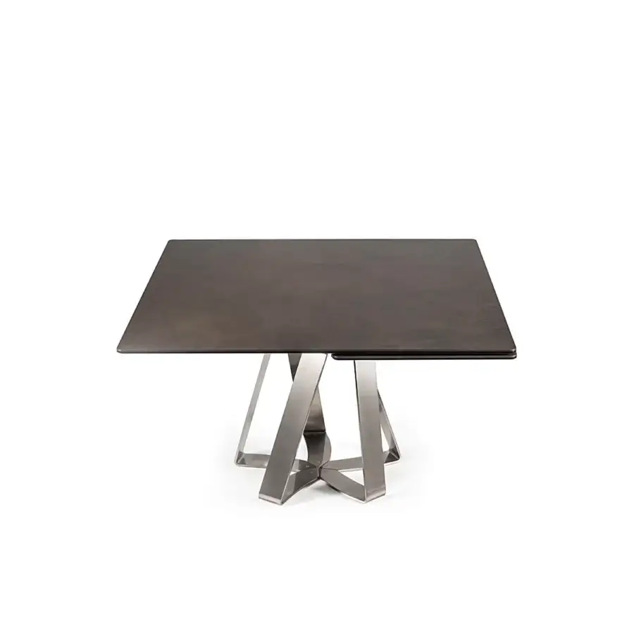 Distinguished Naos turning table with a dark ceramic tabletop and intersecting matte metal legs embodying a contemporary aesthetic