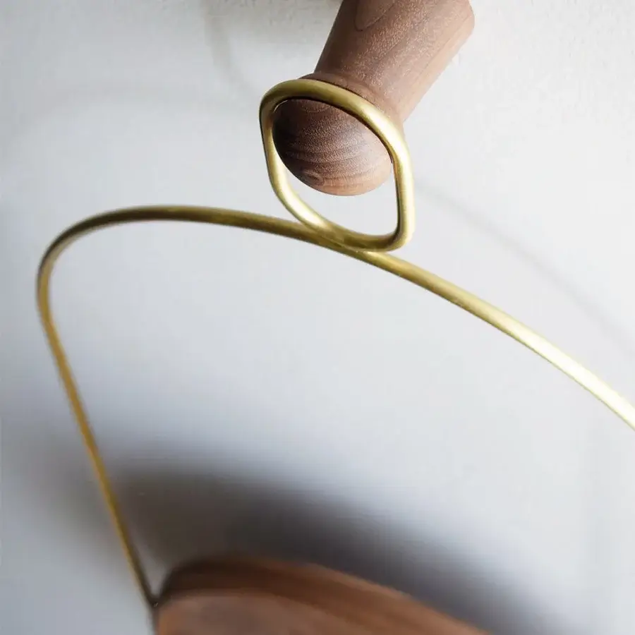 Exceptional Nomon Eslabón Wall Clock crafted in natural walnut with a satin finish and golden-yellow curved metal frame