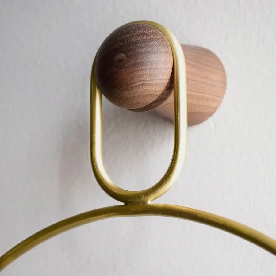 Superior Nomon Eslabón Wall Clock crafted in natural walnut and gold-toned metal with a satin finish