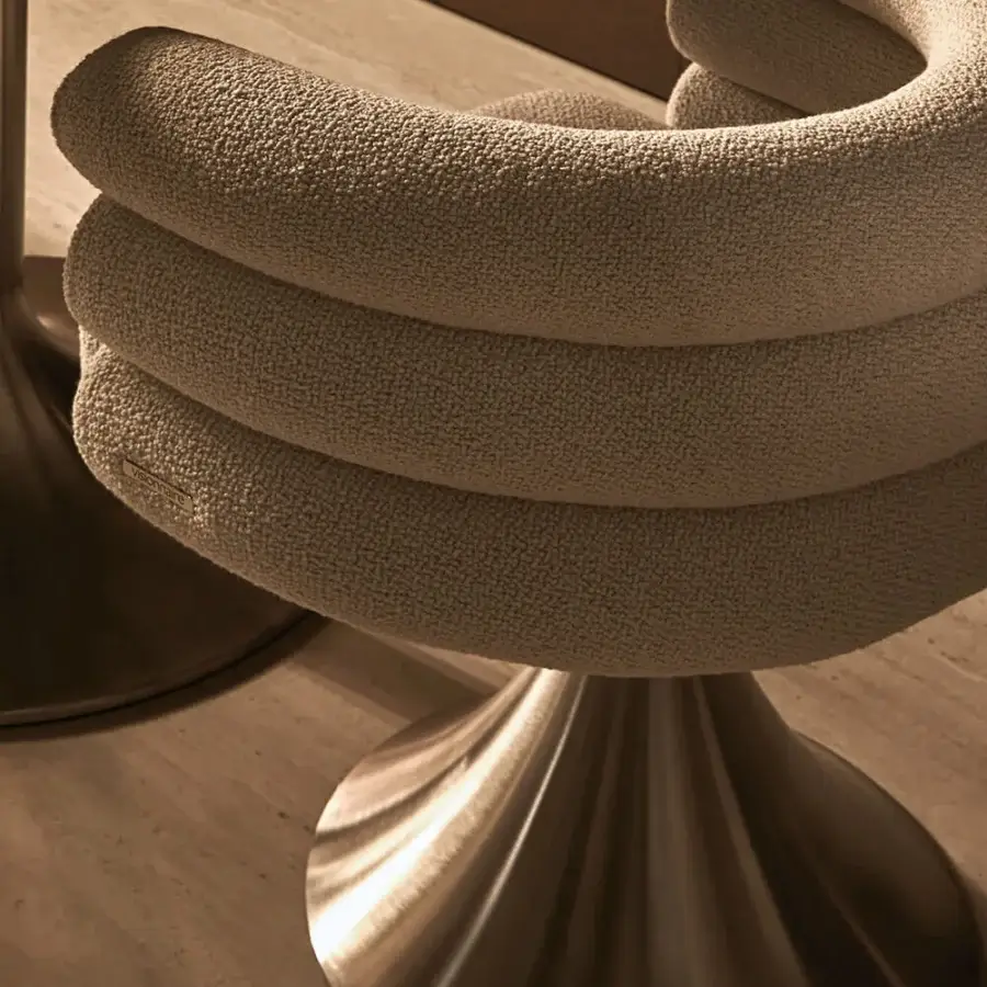 Distinguished Visionnaire Voluptas armchair in textured warm beige bouclé fabric with curved cylindrical bands and satin bronze-like stainless steel base