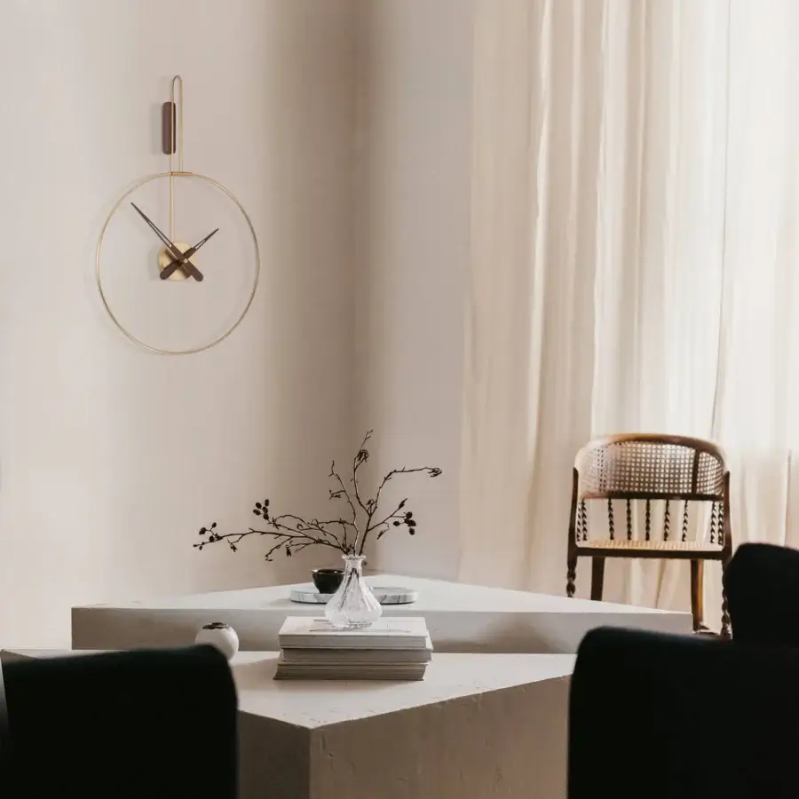 Elegant Nomon Micro Daro wall clock in walnut wood and polished brass presenting harmonious metallic precision