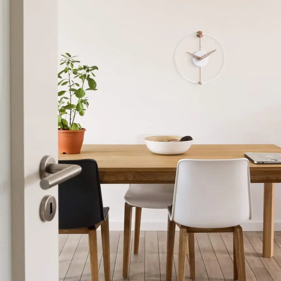 Distinguished Nomon Nano wall clock crafted in walnut wood with a crisp white finish and clean geometry