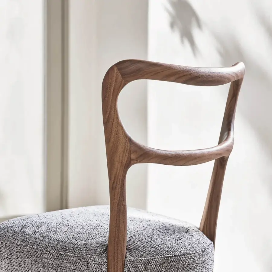 Elegant Porada Noemi chair with a gracefully curved Canaletta walnut frame and grey patterned upholstery offering a warm finish
