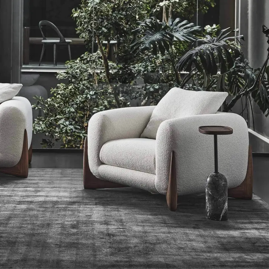Exceptional Porada Softbay armchair with enveloping form, bouclé fabric upholstery and satin Canaletta walnut frame