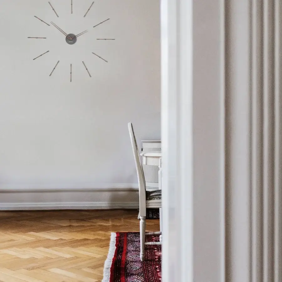 Exceptional Nomon Mini Merlín wall clock crafted with wood and metal in dark gray and light gray hues