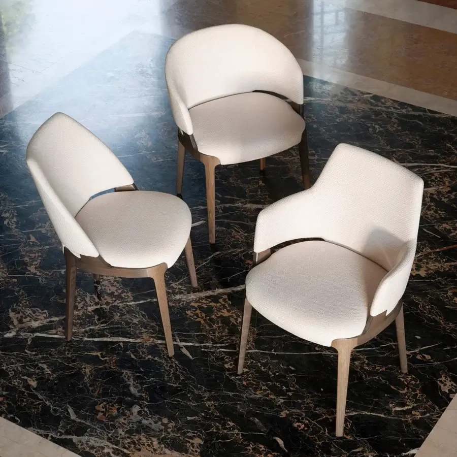 Distinguished Potocco Velis Hug armchair with a gently curved form upholstered in light beige textile and satin-finished wood legs