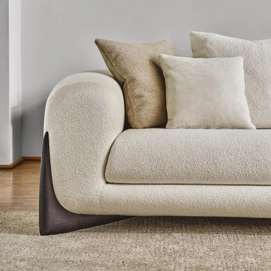 Sumptuous Porada Softbay sofa with curved silhouette and inviting upholstery in cotton, linen, and wool bouclé with a satin Canaletta walnut base