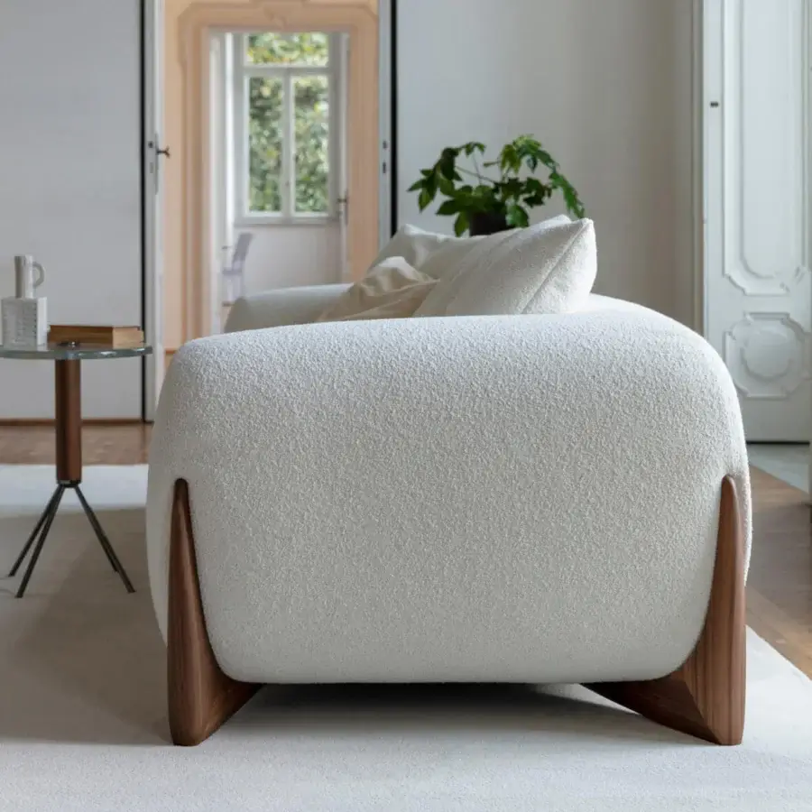 Elegant Porada Softbay sofa with curved form and inviting bouclage upholstery crafted in cotton, linen, and wool with a satin Canaletta walnut base