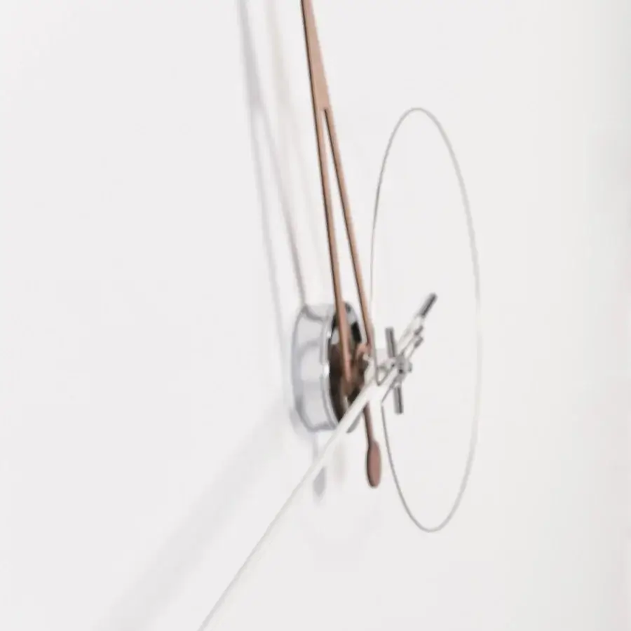 Elegant Nomon Cris wall clock with a metallic ring and warm bronze fiberglass minute hand in a satin finish