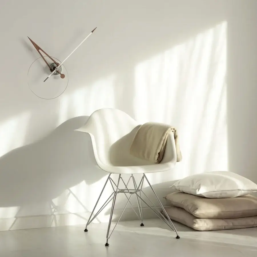 Distinguished Nomon Cris wall clock with a sleek metallic ring and muted bronze fiberglass minute hand in a light beige face