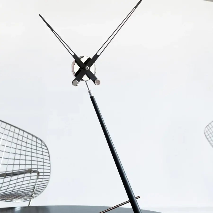 Superior Nomon Puntero table clock built with matte black wood and polished metal creating a minimalist silhouette with slender hands