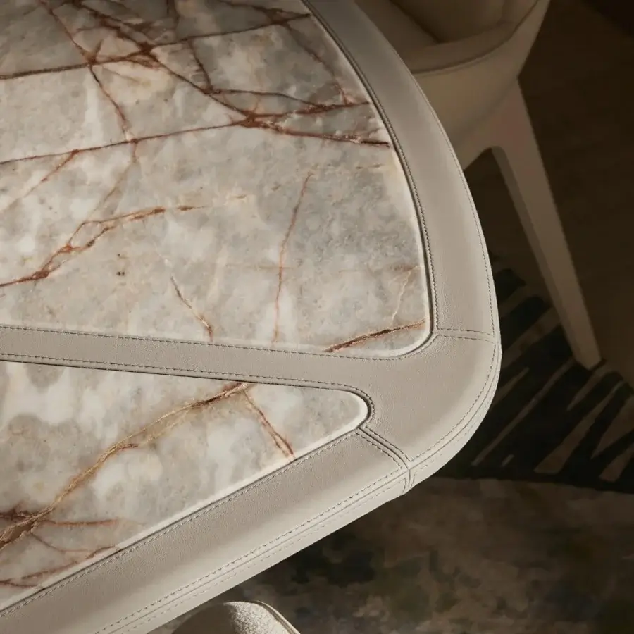Lavish Visionnaire Vortex table with light grey marble effect, warm gold veining and a pale beige leather band in satin-finished steel