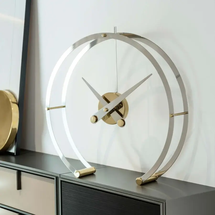 Avant-garde Nomon Omega table clock with connected steel rings and subtle brass-toned accents in polished silver finish