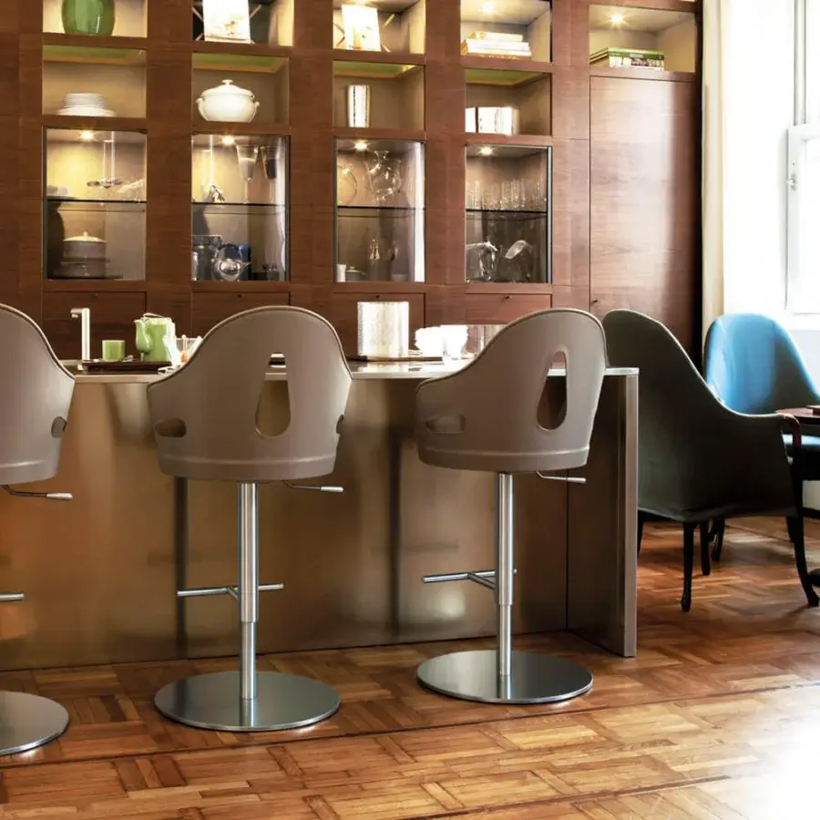 Elegant Giorgetti Dora stool in taupe saddle leather with a polished stainless steel swivel base and integrated footrest