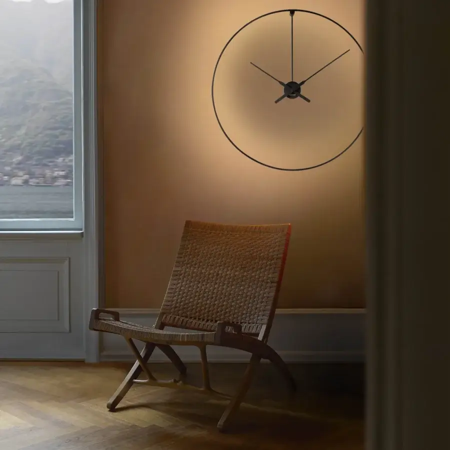 Exceptional Nomon Ombra clock lamp with a black anodized aluminum ring emitting a warm gradient glow
