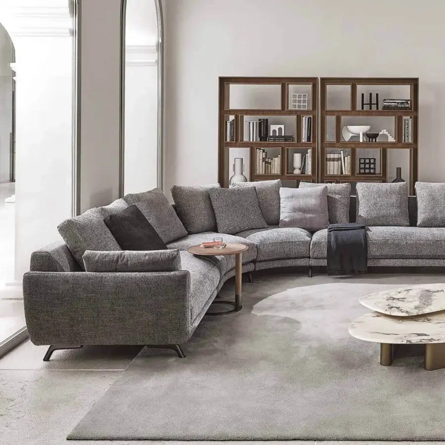 Lavish Porada Étienne sofa with curved form upholstered in neutral gray Microflock and pewter grey metal feet with wooden inserts