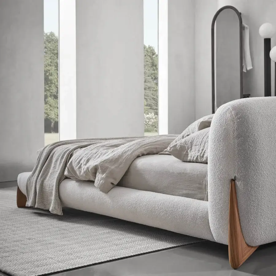 Elegant Porada Softbay bed upholstered in light neutral beige textile with distinctive solid Canaletta walnut wood end-feet and matte finish