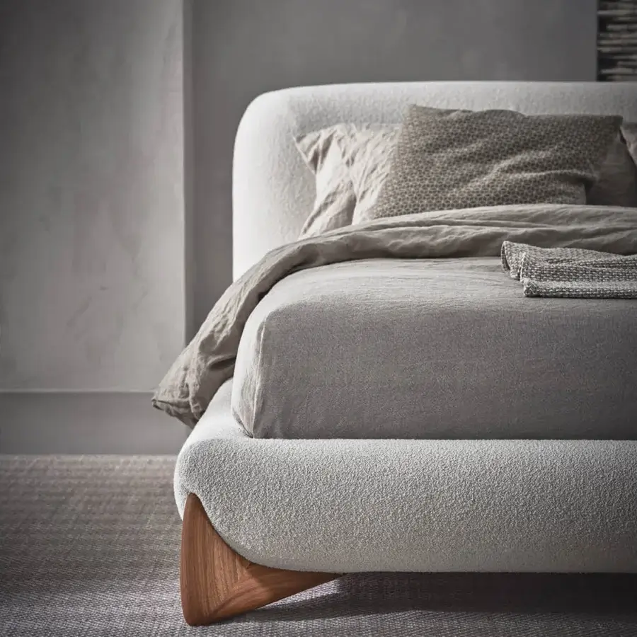 Distinguished Porada Softbay bed upholstered in textured light beige textile with solid Canaletta walnut wood end-feet