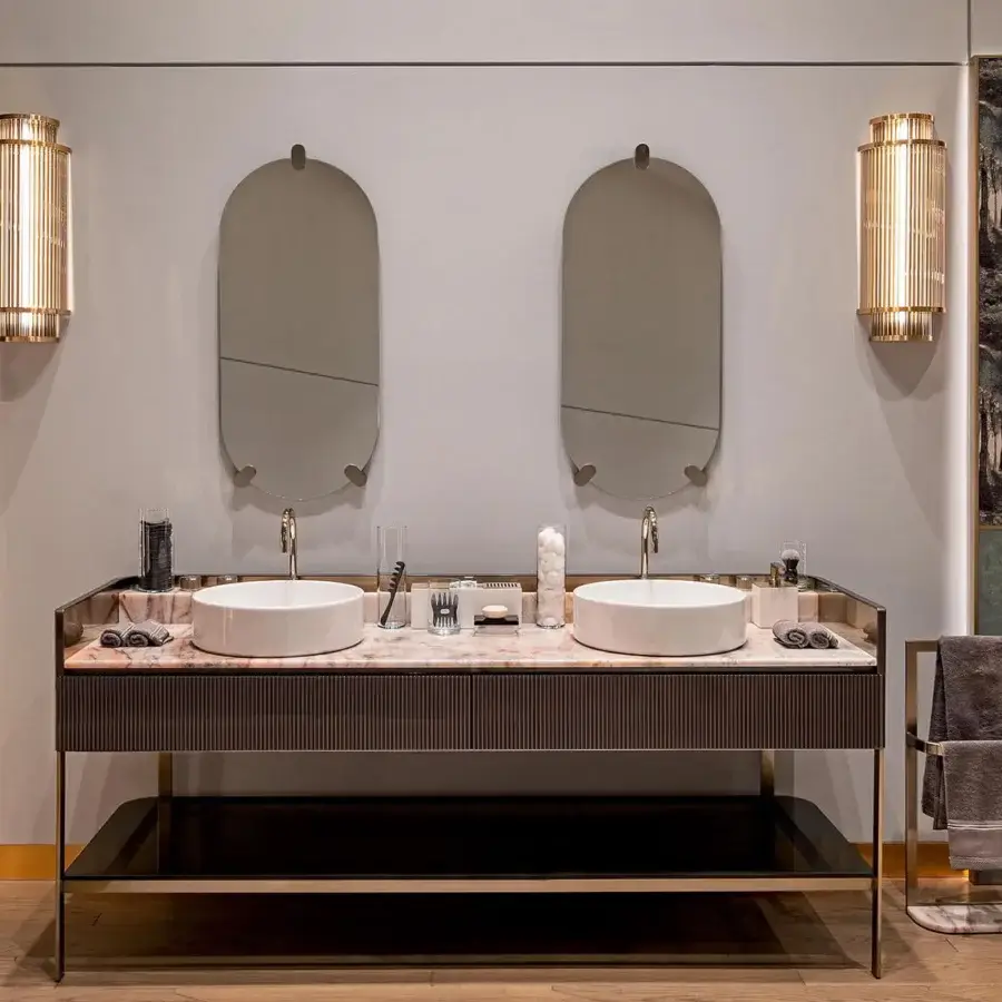 Superior Visionnaire Giano Wall Applique, a sculptural fixture built with satin steel and PVD gold finish, displaying dual semi-cylindrical bodies