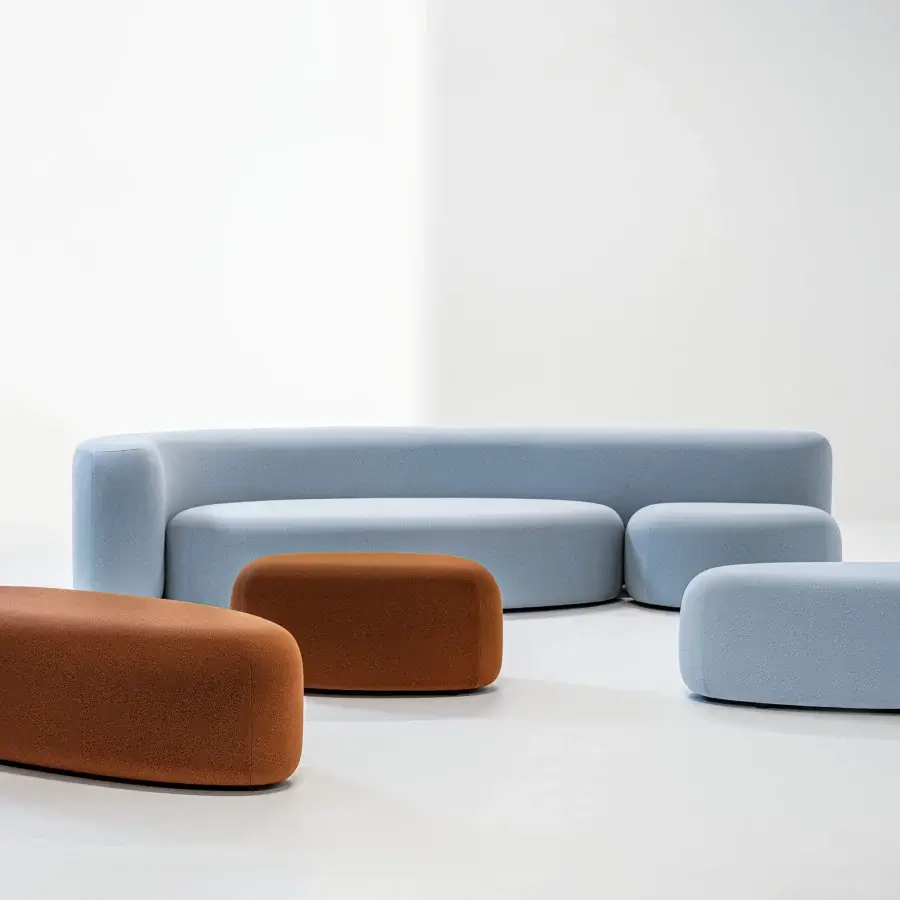 Distinguished LaCividina Lisse sofa with sinuous form upholstered in pale blue two-way stretch fabric and matte finish, accompanied by warm brown ottomans