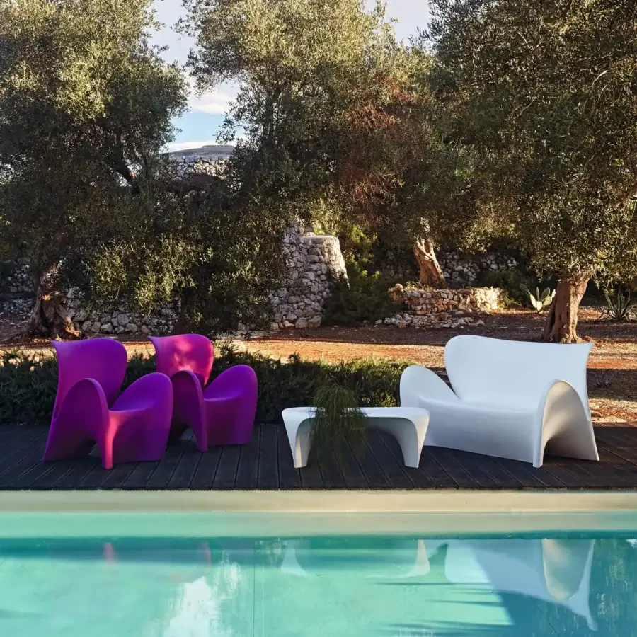 Avant-garde MY YOUR Lily lounge chair with glossy plastic sculpted in a continuous fuchsia hue embodying a fresh Italian aesthetic