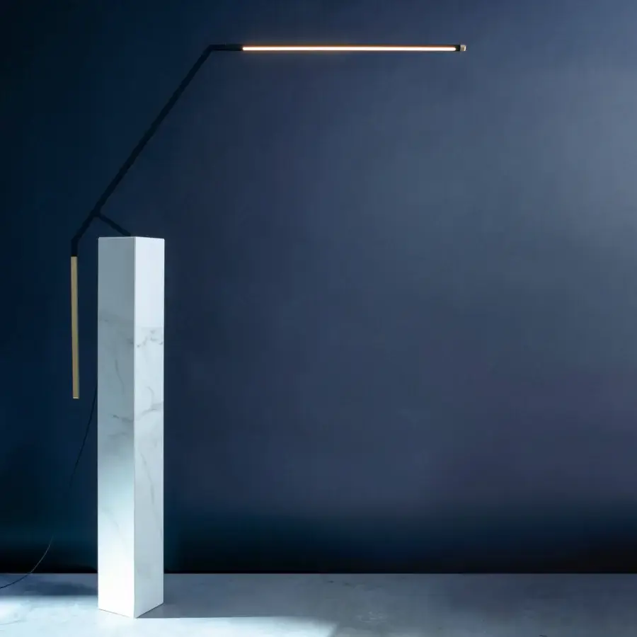 Elegant Nemo Bird table lamp in matte black metal with pale orange-yellow illuminated panel achieving balanced diffused light
