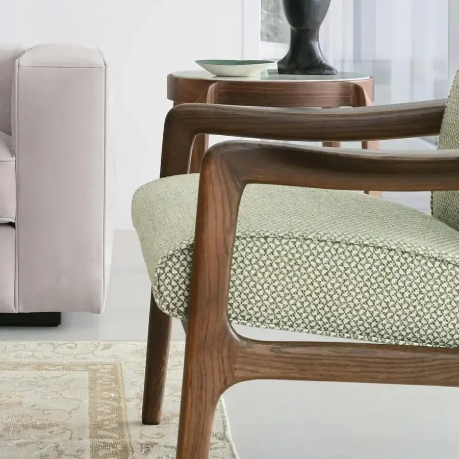 Sophisticated CTS Salotti Jack lounge chair with a curved form upholstered in textured sage green textile and a satin Canaletto walnut frame