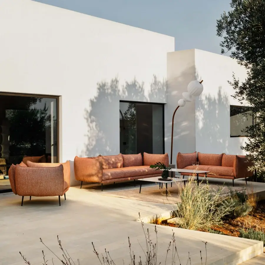 Exceptional MY YOUR Piuma sofa built with aluminum, showcasing reddish-orange textured fabric and highlighted stitching for outdoor use