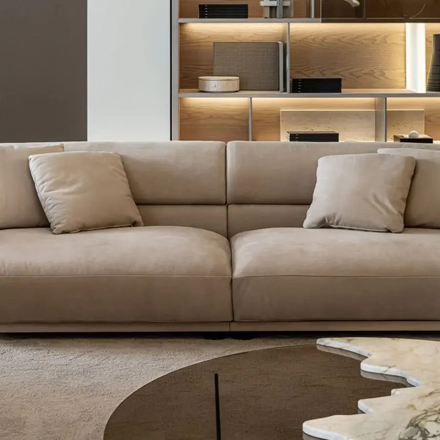 Superior Shake Vogue sofa with low wide form and gently curved silhouette upholstered in warm neutral beige textile with varnished steel feet
