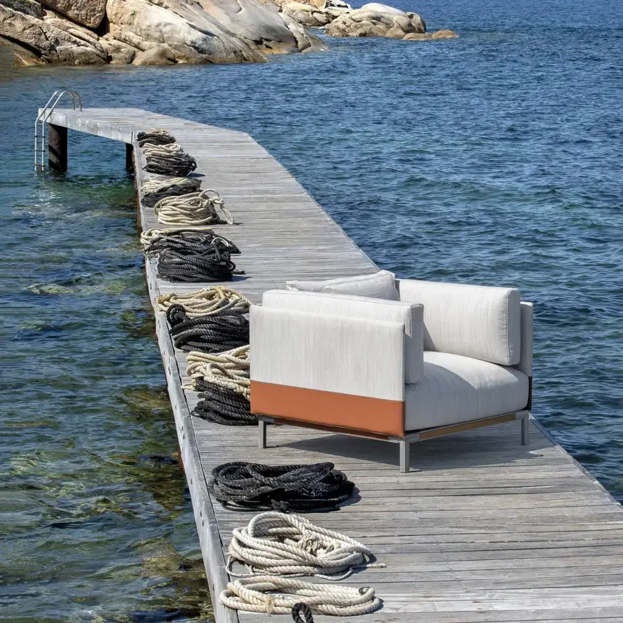 Refined Ethimo Baia lounge chair crafted in dark bronze metal with light beige textured textile and terracotta accent
