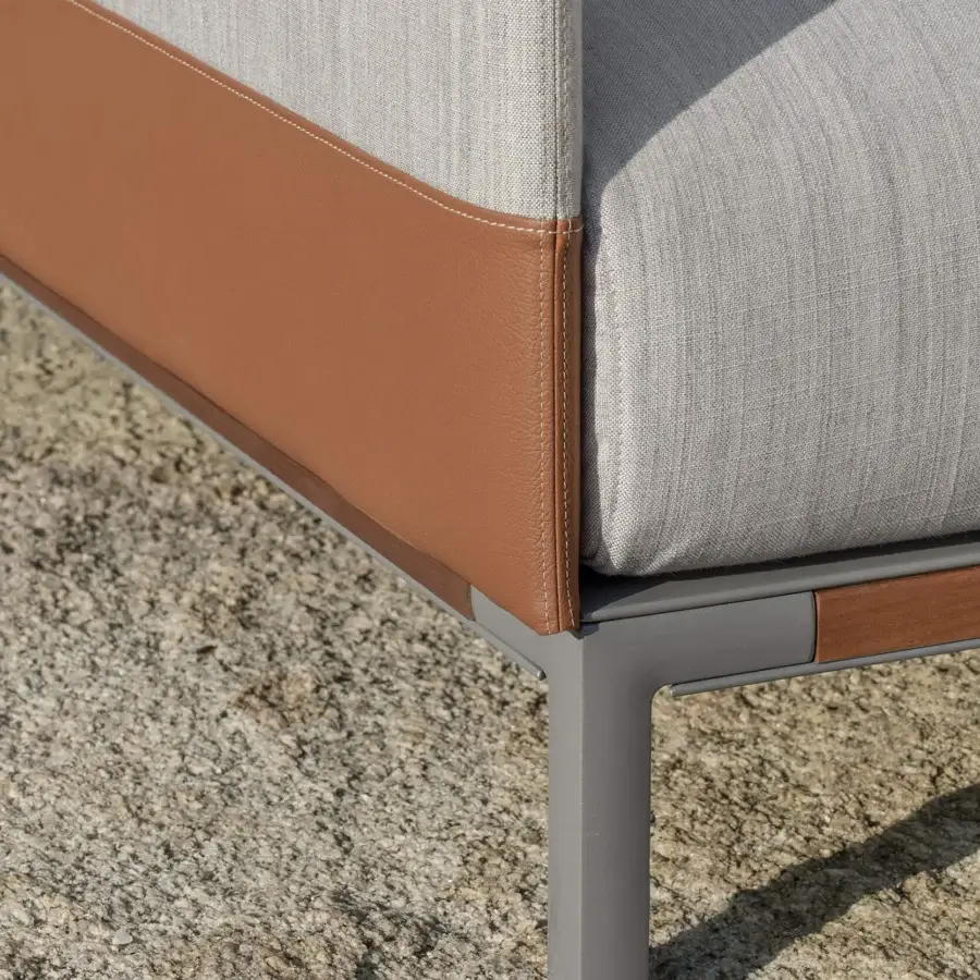 Refined Ethimo Baia daybed with a grey metal frame and light grey textile upholstery accented by reddish-brown fabric panels