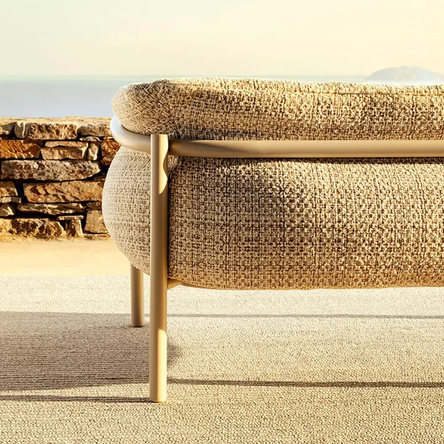 Superior Varaschin Allegra sofa with curved lines and plush beige textured cushions built with a light gold powder-coated aluminum frame