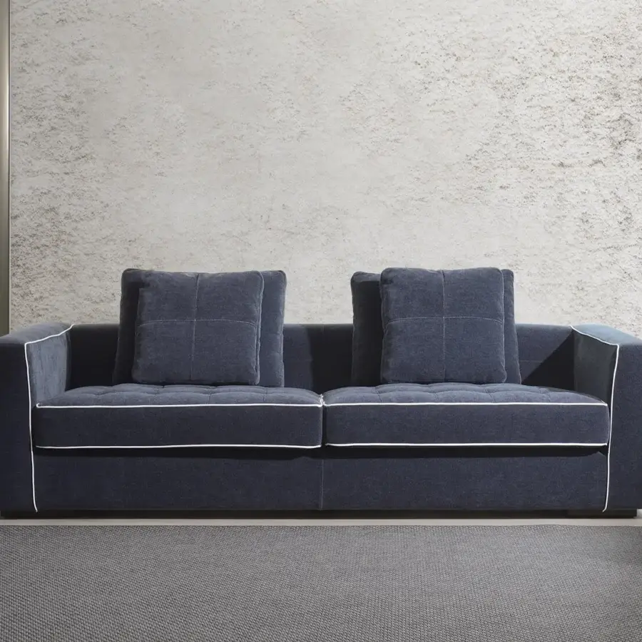 Elegant CTS Salotti Clay sofa with dark navy textile upholstery, white piping and quilted seat cushions built with a stained beech base