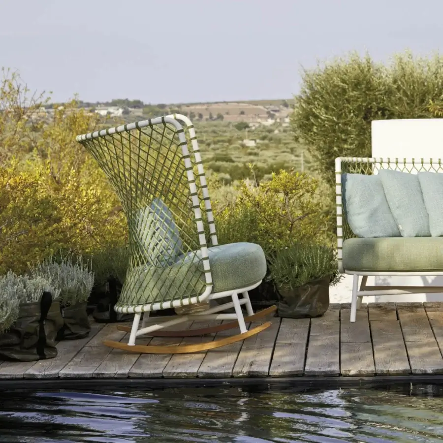 Elegant Roberti Rattan Charme rocking lounge chair with white powder-coated steel, green woven accents, and a blue-green cushion