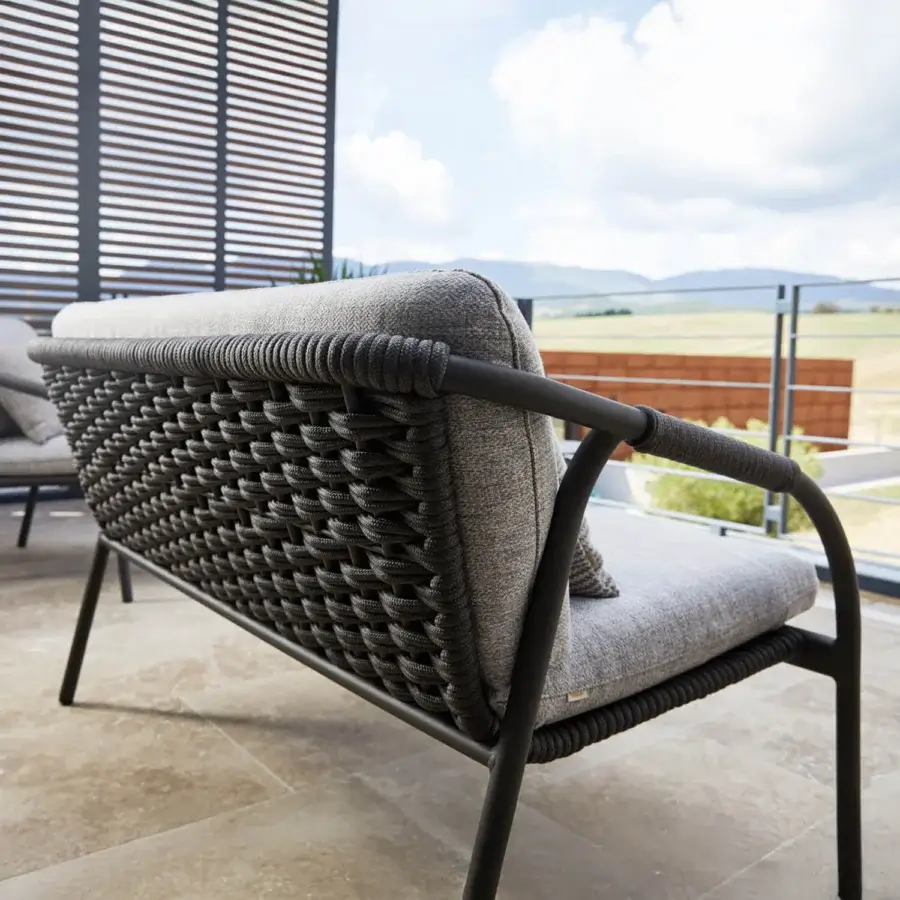 Distinguished Roberti Rattan Capri sofa crafted with durable searope and powder-coated aluminum in textured dark gray textile