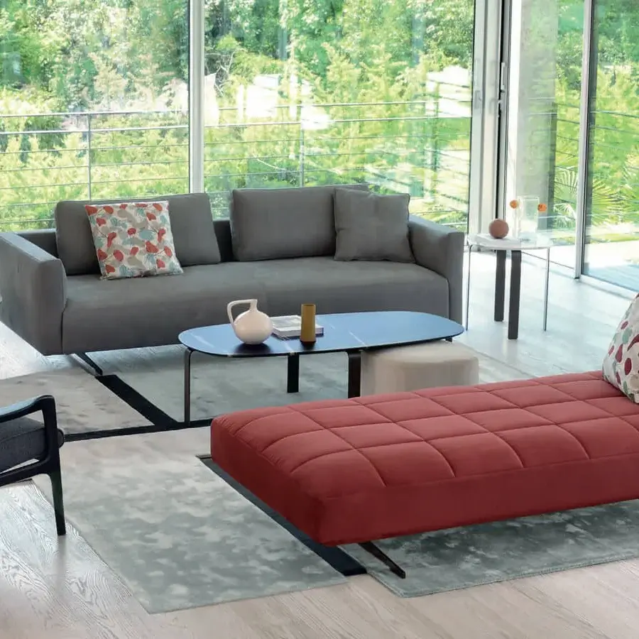 Elegant CTS Salotti Ikon sofa with medium gray textile upholstery and a contrasting coral-red chaise lounge built with painted steel