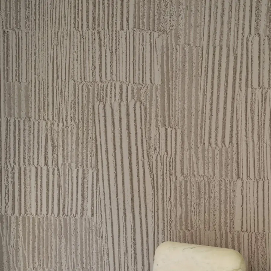 Distinguished Wall&Decò Engraving wallpaper presents a fabric-effect surface with muted beige tones and layered geometric striations in organic bio-vinyl