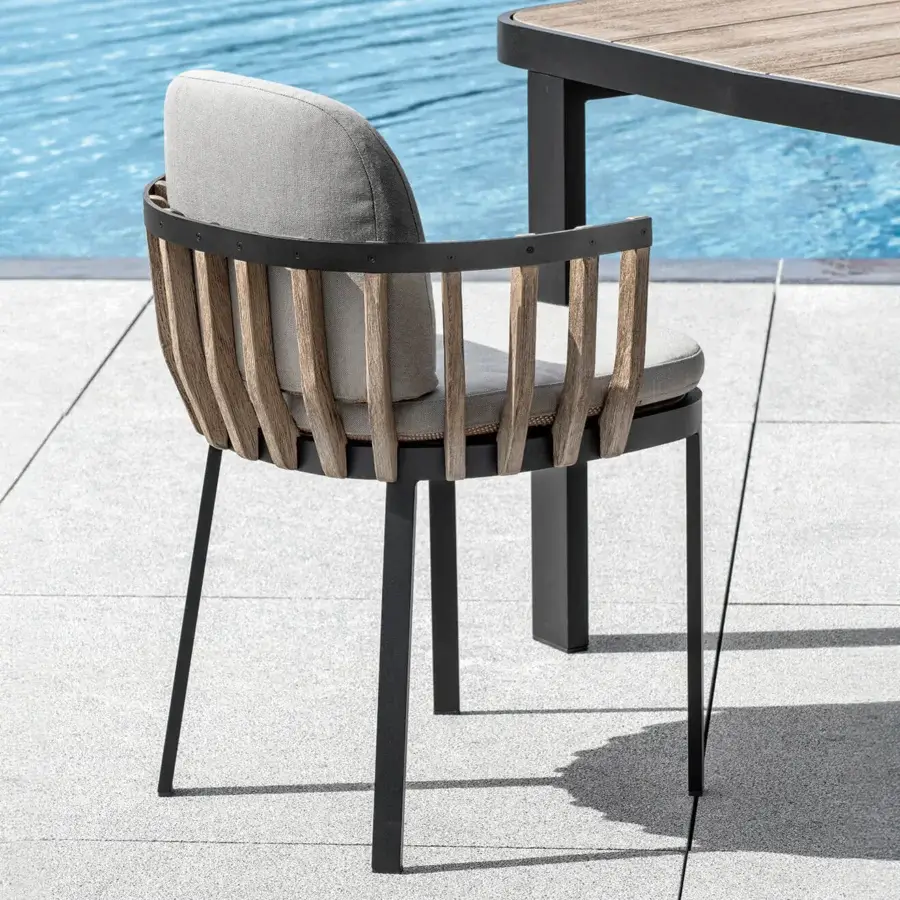 Distinguished Ethimo Swing armchair with a dark gray metal frame and precisely arranged teak slats, completed with light gray cushions