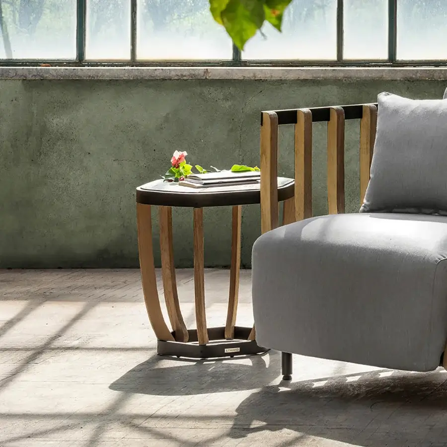 Captivating Ethimo Swing side table with a dark-toned metal base and precisely arranged teak slats exhibiting a warm medium-brown hue