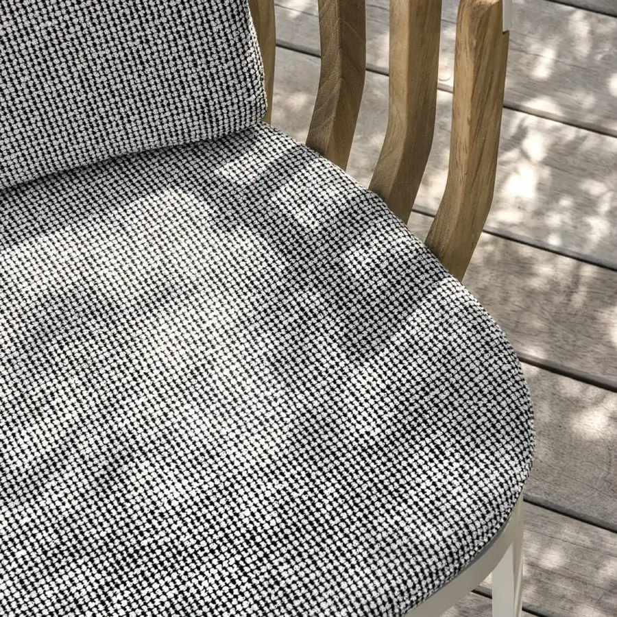 Sophisticated Ethimo Swing lounge chair with a white metal frame and teak slats, built in textured black and white textile upholstery
