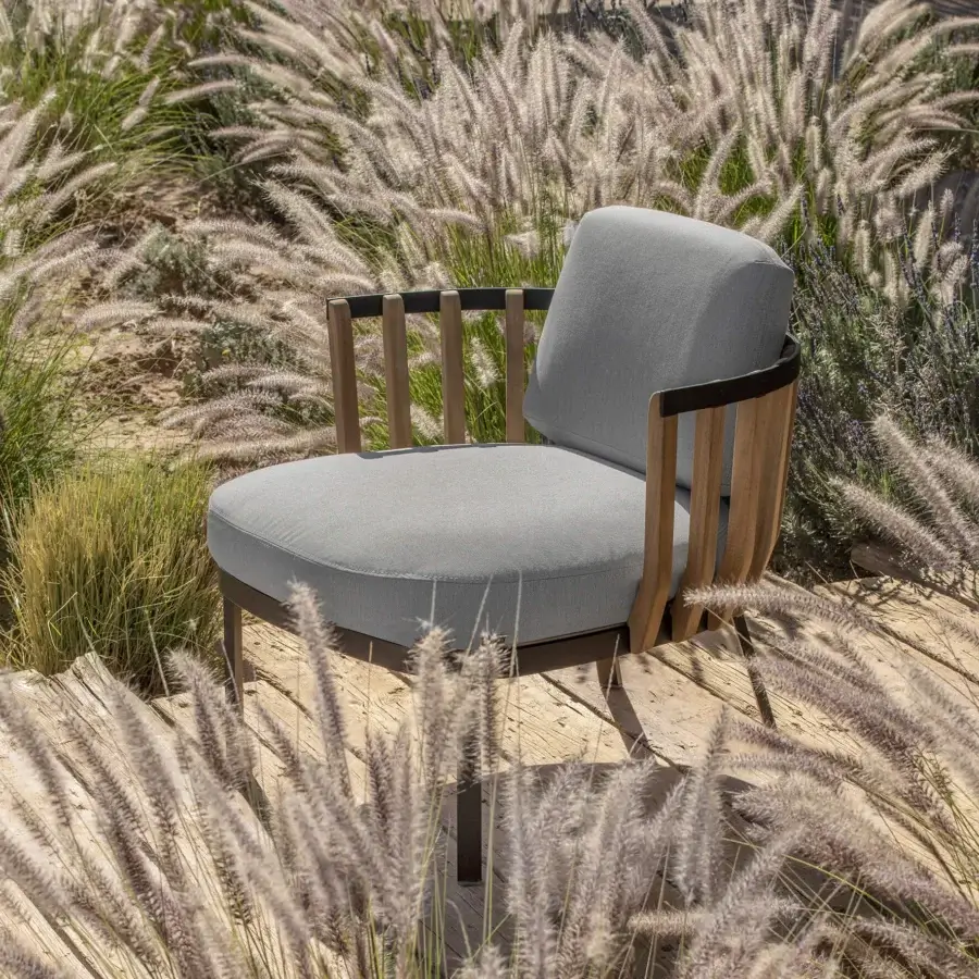 Harmonious Ethimo Swing lounge chair built with muted gray textile, a metal frame and precisely arranged teak slats for refined repose