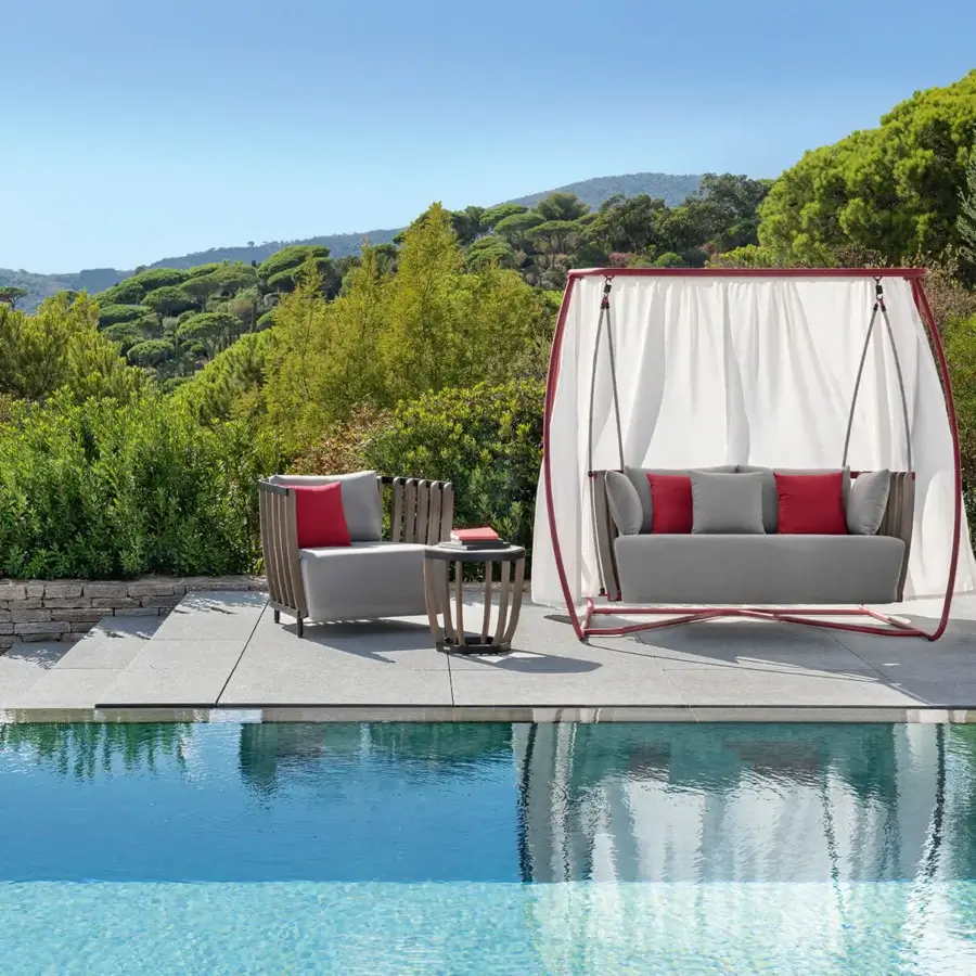 Exceptional Ethimo Swing lounge chair with a metal frame, warm teak slats and bright white textile canopy in a smoothly finished reddish-brown arch