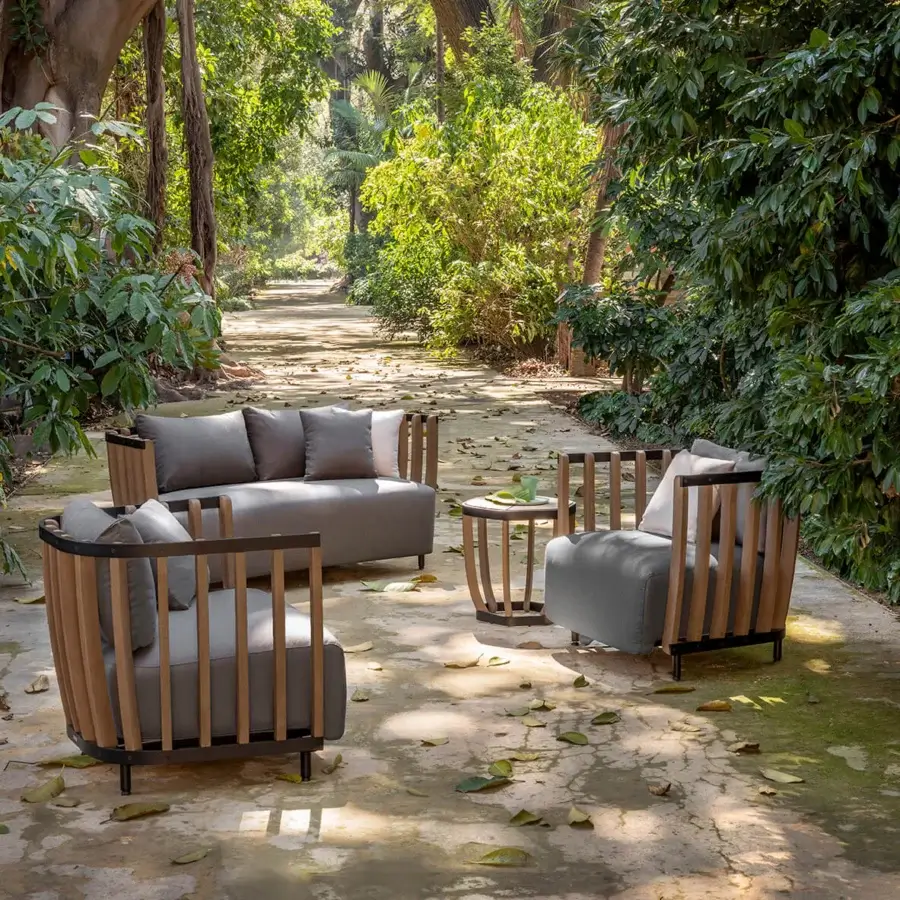Distinguished Ethimo Swing sofa with an architectural metal frame, warm teak slats, and neutral gray textile cushions