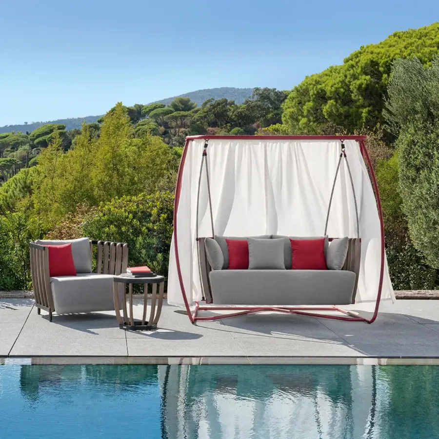 Captivating Ethimo Swing hanging sofa with a satin-finish red metal frame and rhythmic teak slats suspended by elegant ropes with gray cushions