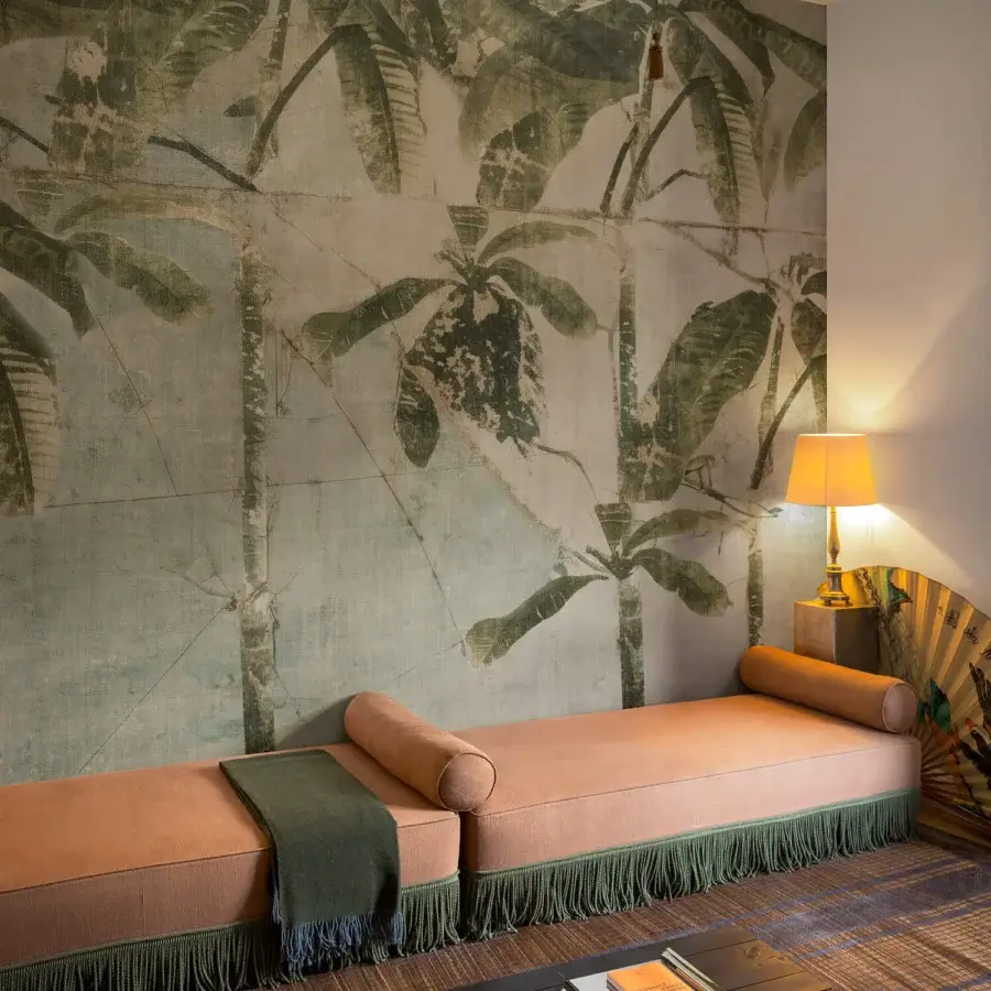 Elegant Wall&Decò La Aldaba wallpaper with muted green and beige palm fronds crafted in sustainable d.ecodura™ organic bio-vinyl with fabric-effect texture