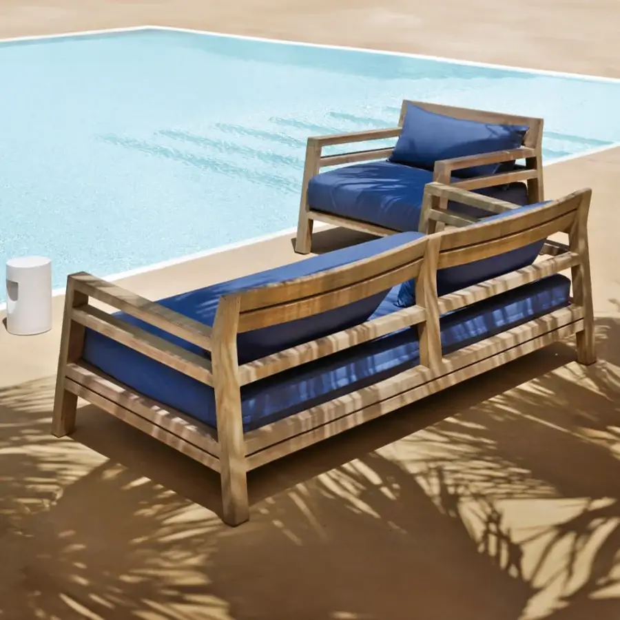 Distinguished Ethimo Costes sofa crafted with FSC-certified teak wood in a natural finish with deep blue textile cushions