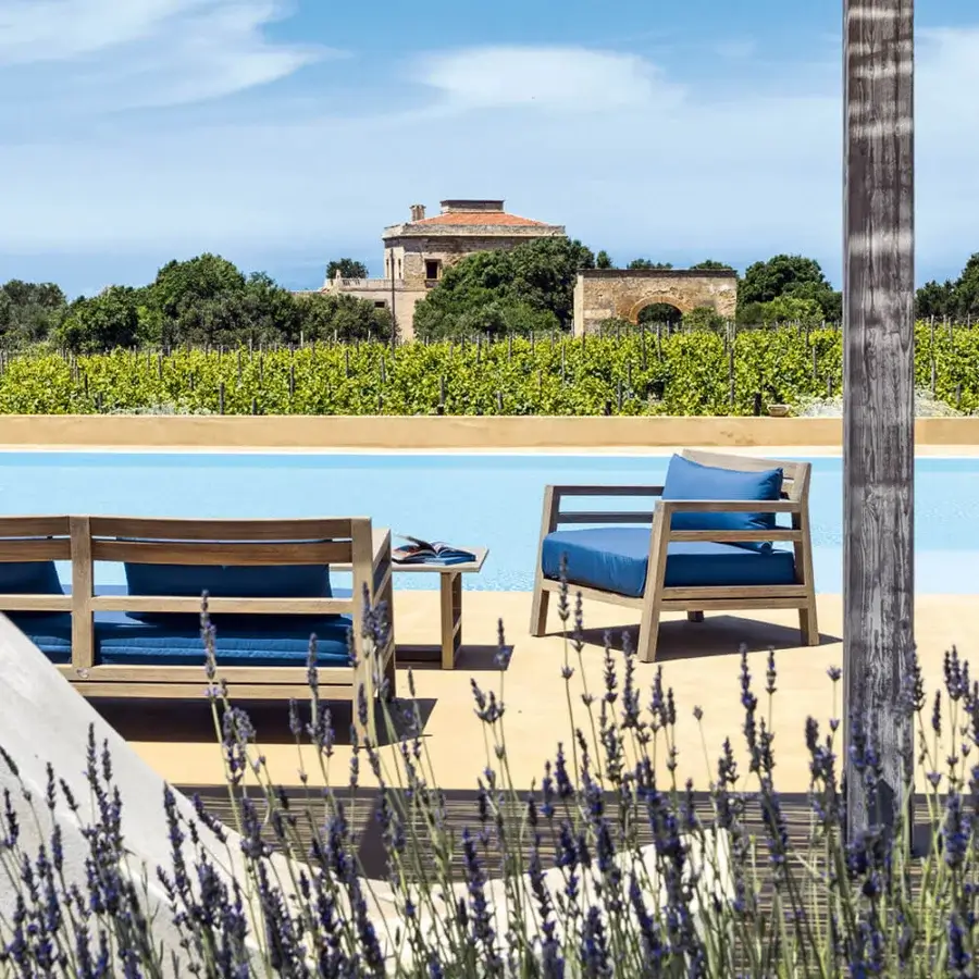 Superior Ethimo Costes lounge chair with FSC-certified teak and bright blue cushions in a pickled finish