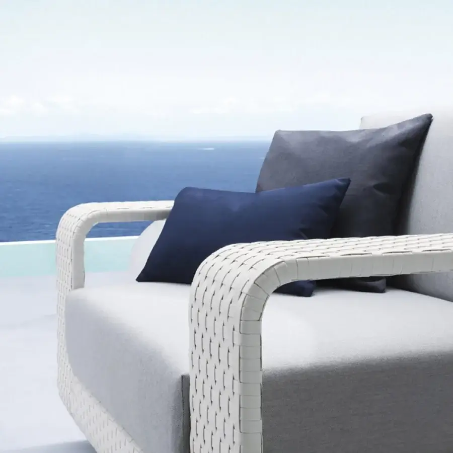Superior Roberti Rattan Hamptons lounge chair with durable aluminum and textured Sunweave, complemented by gray textile with navy cushions