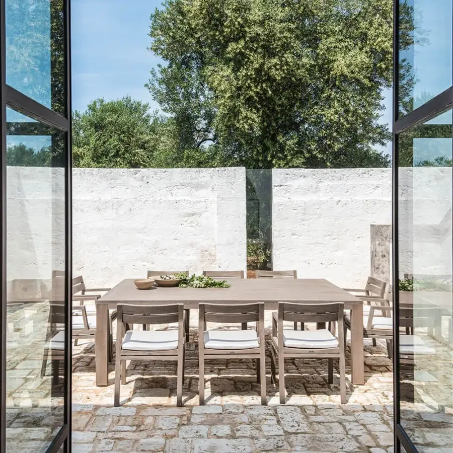 Superior Ethimo Costes armchair with FSC-certified teak structure and warm natural finish creating a minimalist aesthetic